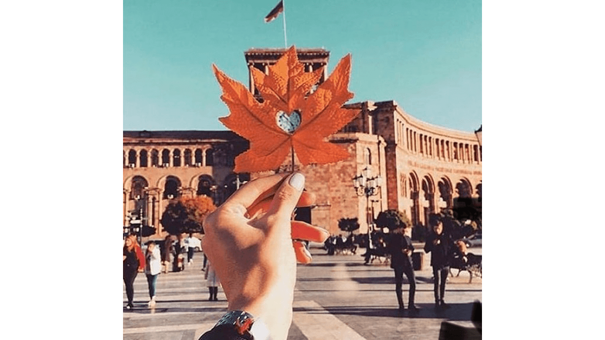 تصویری از یک برگ در دست یک فرد در میدان جمهوری ایروان در پائیز